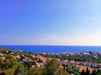 High angle view of townscape by sea against sky