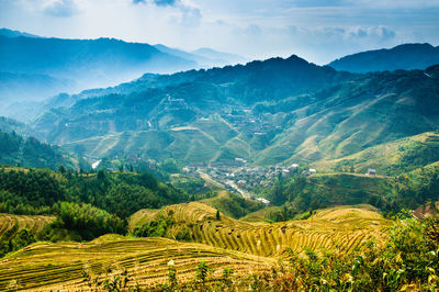 Scenic view of field and mountains against sky