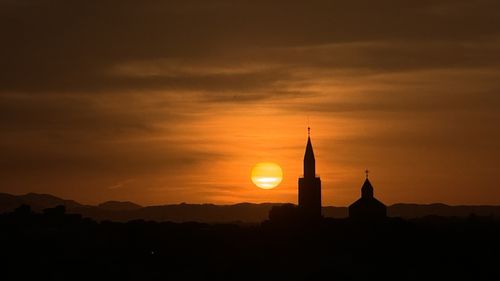 Low angle view of silhouette buildings against sky during sunset