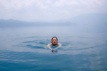 PORTRAIT OF WOMAN SWIMMING IN WATER