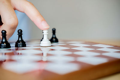 Cropped hand of person playing chess at home