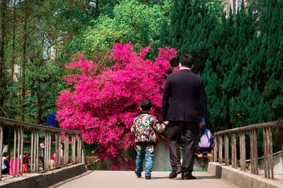 Rear view of people walking on footbridge