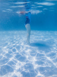 Rear view of man swimming in pool