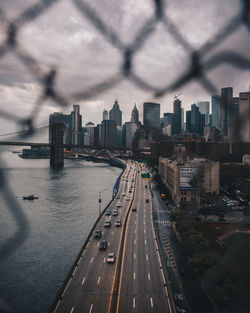 High angle view of city buildings against cloudy sky