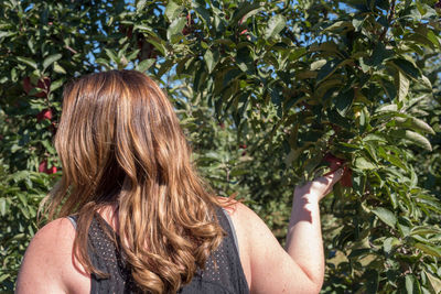 Rear view of a woman against tree