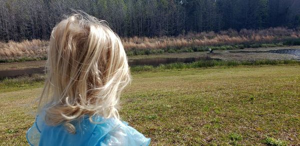 Rear view of woman in grassy field