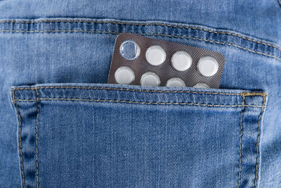 Close-up of medicines in jeans pockets