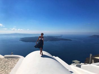 Woman walking on built structure against seascape