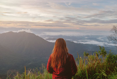 Rear view of woman looking at mountain range against sky