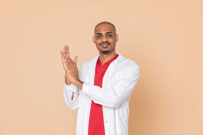 Portrait of smiling man against gray background