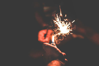 Close-up of hand holding sparkler at night