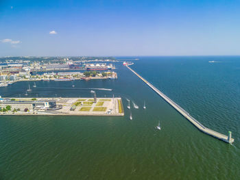 High angle view of sea by city buildings against sky