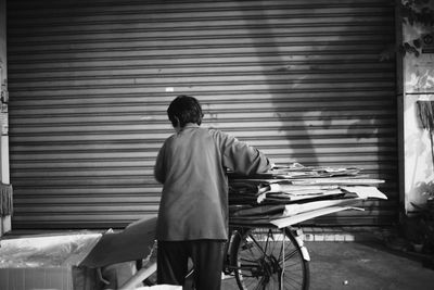 Rear view of man standing against wall