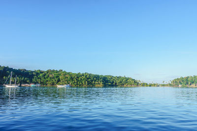 Scenic view of lake against clear blue sky