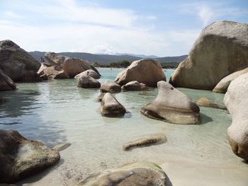 Rocks in sea against sky