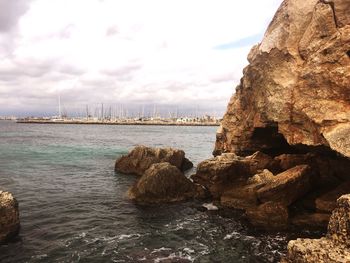 Rock formations by sea against sky