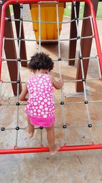 Girl climbing on the rope playing in the park