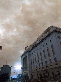 Low angle view of buildings against cloudy sky