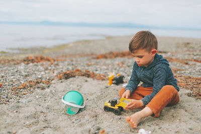 Boy playing with toys on beach
