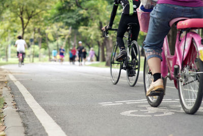 Low section of people riding bicycle on road