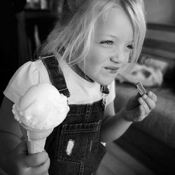 Smiling girl eating chocolate and ice cream at home