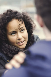 Young woman looking at man outdoors