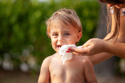 Portrait of shirtless boy holding baby