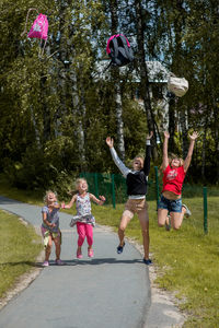 Siblings jumping over road in city