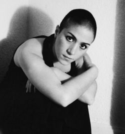 Portrait of young woman standing against wall at home