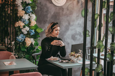 Woman sitting on table in restaurant