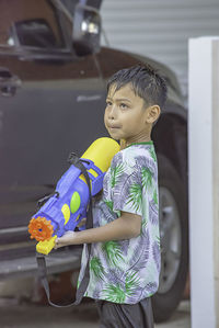 Side view of boy playing with squirt gun