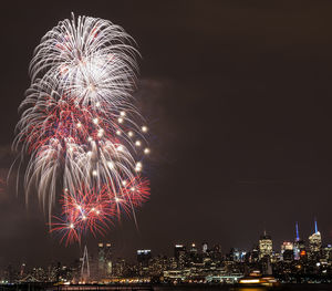 Low angle view of firework display against sky at night