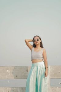 Young woman standing against clear sky