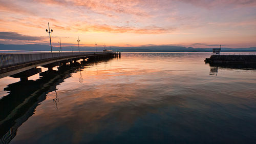 Pier over sea against sky during sunset