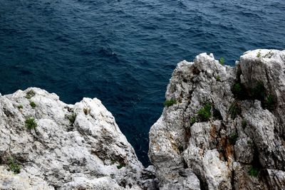 High angle view of rocks on sea shore