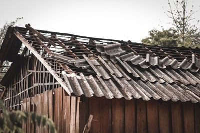 Low angle view of damaged roof of building against sky