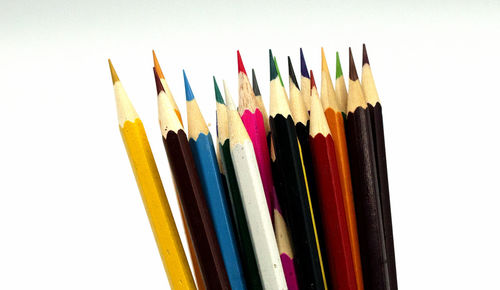 Close-up of colored pencils against white background