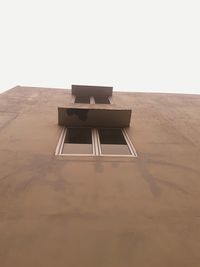 Low angle view of empty chair on table against sky