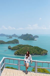 Full length of woman standing against seascape and sky