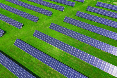 Solar panels in green field, aerial view