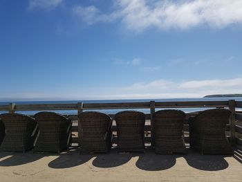 Chairs on beach against sky