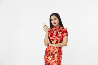 Portrait of beautiful woman standing against white background