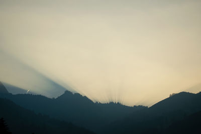 Scenic view of silhouette mountains against sky at sunset