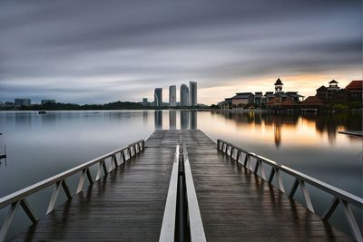 Jetty over water at sunset