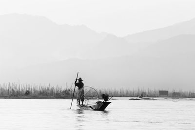 People on lake against sky