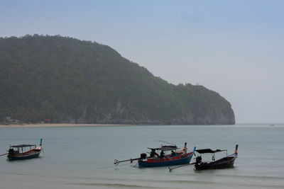 Boats moored on sea against sky