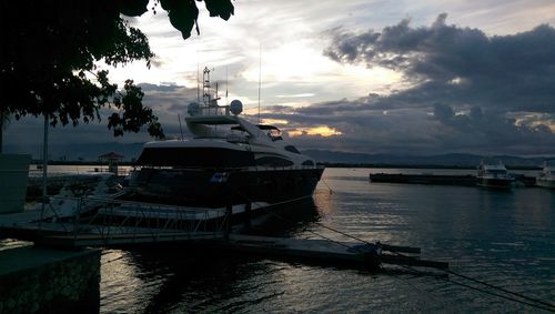 Boats in sea at sunset