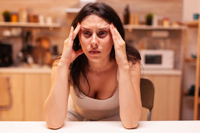 Portrait of young woman sitting at home