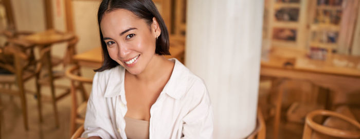 Young woman looking away while standing at home