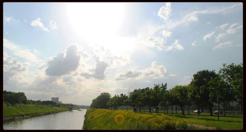 Scenic view of river against cloudy sky